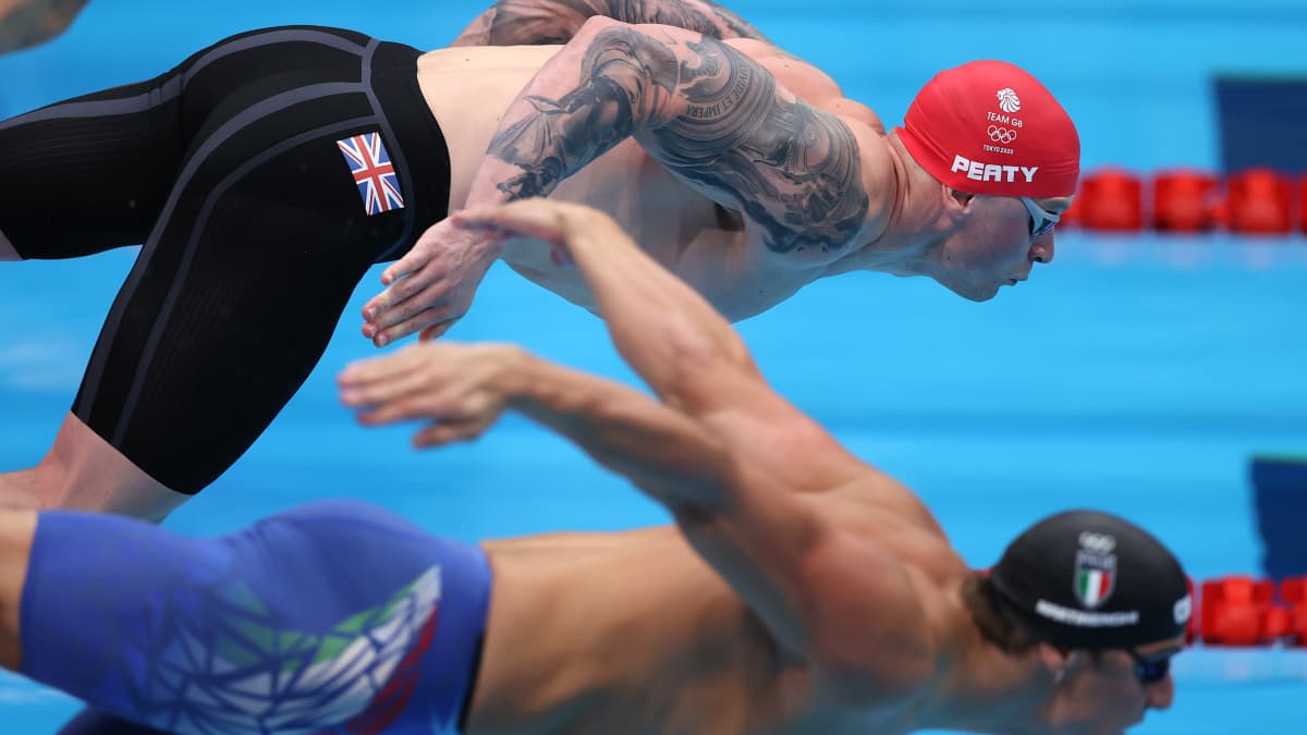Maailman paras rintauimari Adam Peaty hyppää altaaseen Tokion olympialaisissa. 
