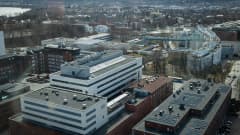 YTHS:n rakennukset kuvattuna yläilmoista, korkealta savupiipusta. Taustalla näkyy myös Tampereen yliopiston rakennuksia ja Tamperetta.