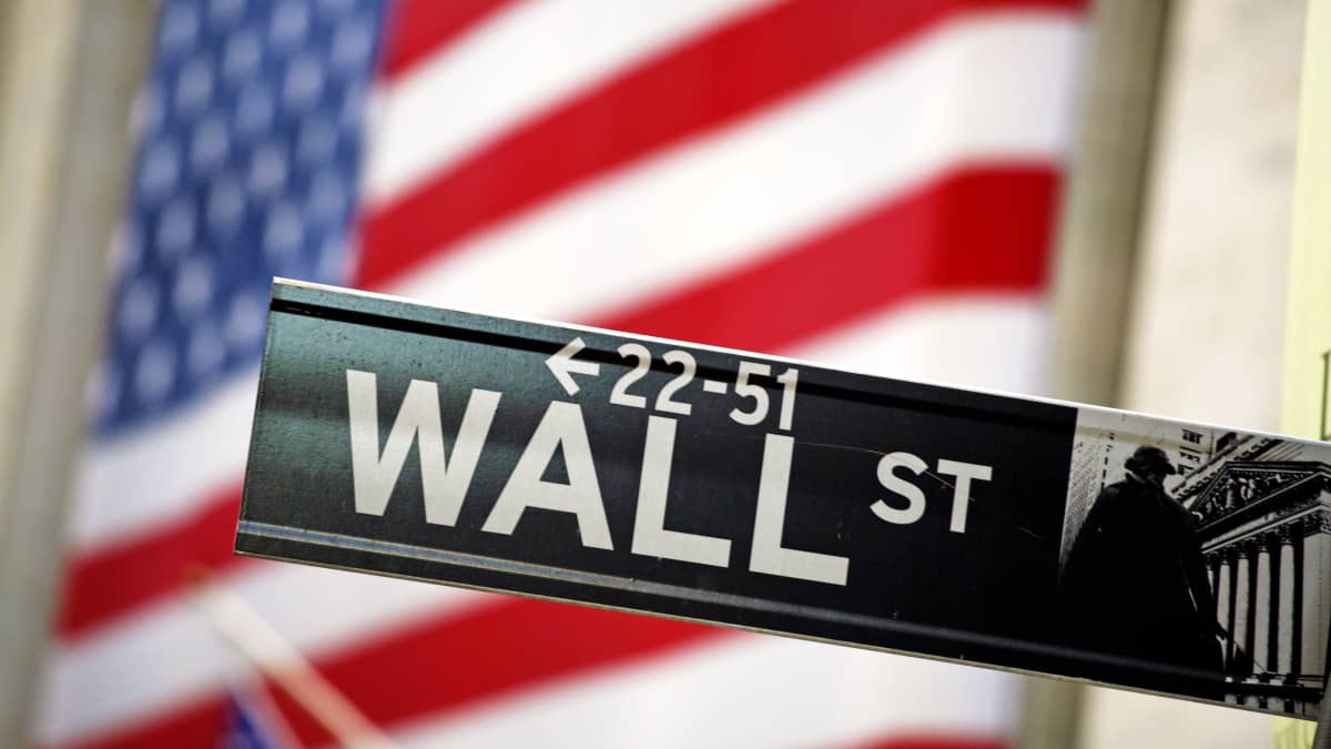 Wall Street -kyltti Yhdysvaltain lipun edessä.