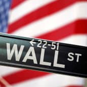 Wall Street -kyltti Yhdysvaltain lipun edessä.