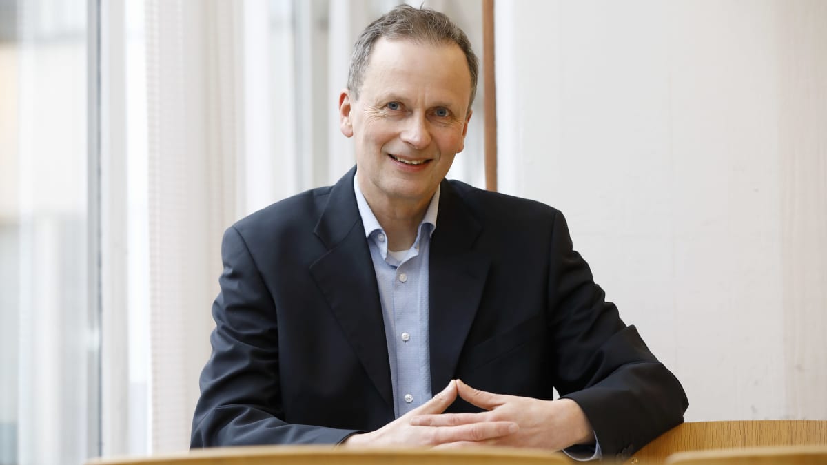 Helsingin yliopiston rikosoikeuden professori Kimmo Nuotio istuu ja katsoo kameraan hymyillen.