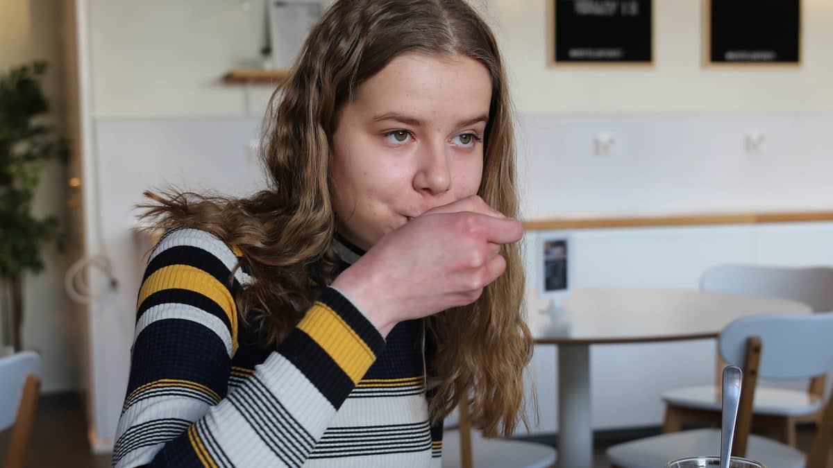 Salla Mäki syö leivosta kahvilassa.