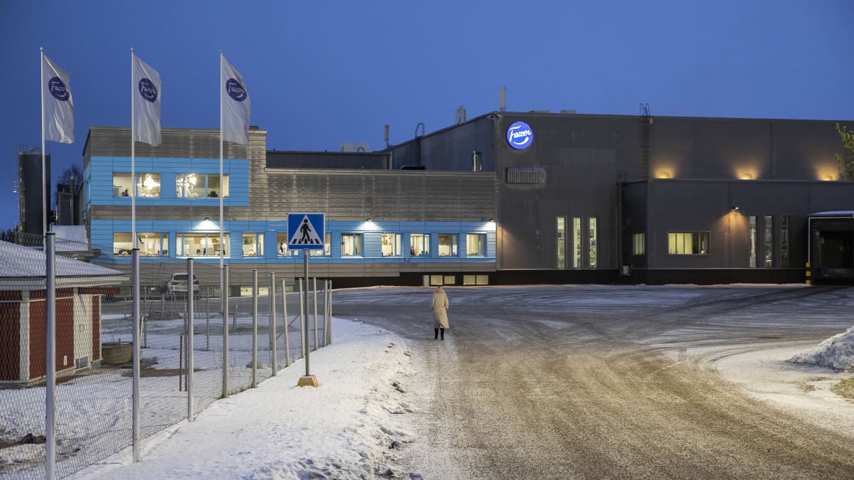 Fazerin tehdas Korialla Kouvolassa ja tehtaalle kävelevä nainen.