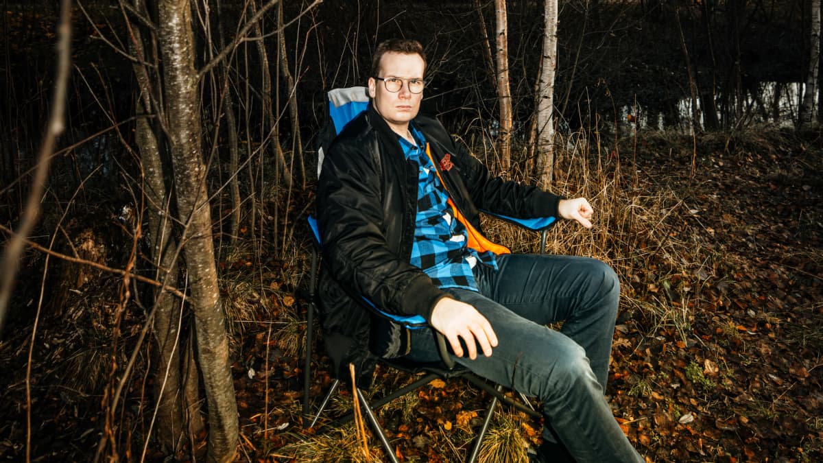 Janne Rinta istuu retkituolissa pihlajan alla jossa vain marjat jäljellä.