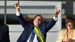 Brasilian presidentti Luiz Inacio Lula da Silva osoittaa etusormillaan ylös vaimonsa Rosangela da Silvan vieressä.