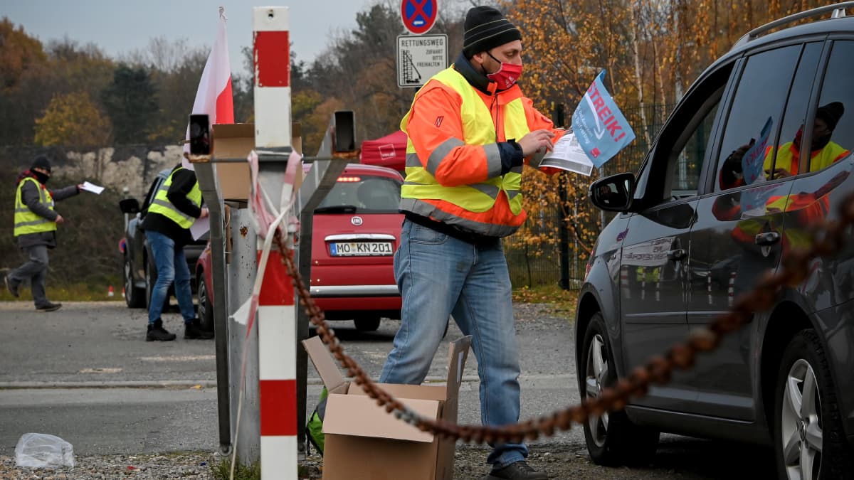 Lakkoilevat työntekijät jakoivat torstaina lehtisiä lähellä Amazonin kuljetuskeskusta Rheinbergissä, Saksassa