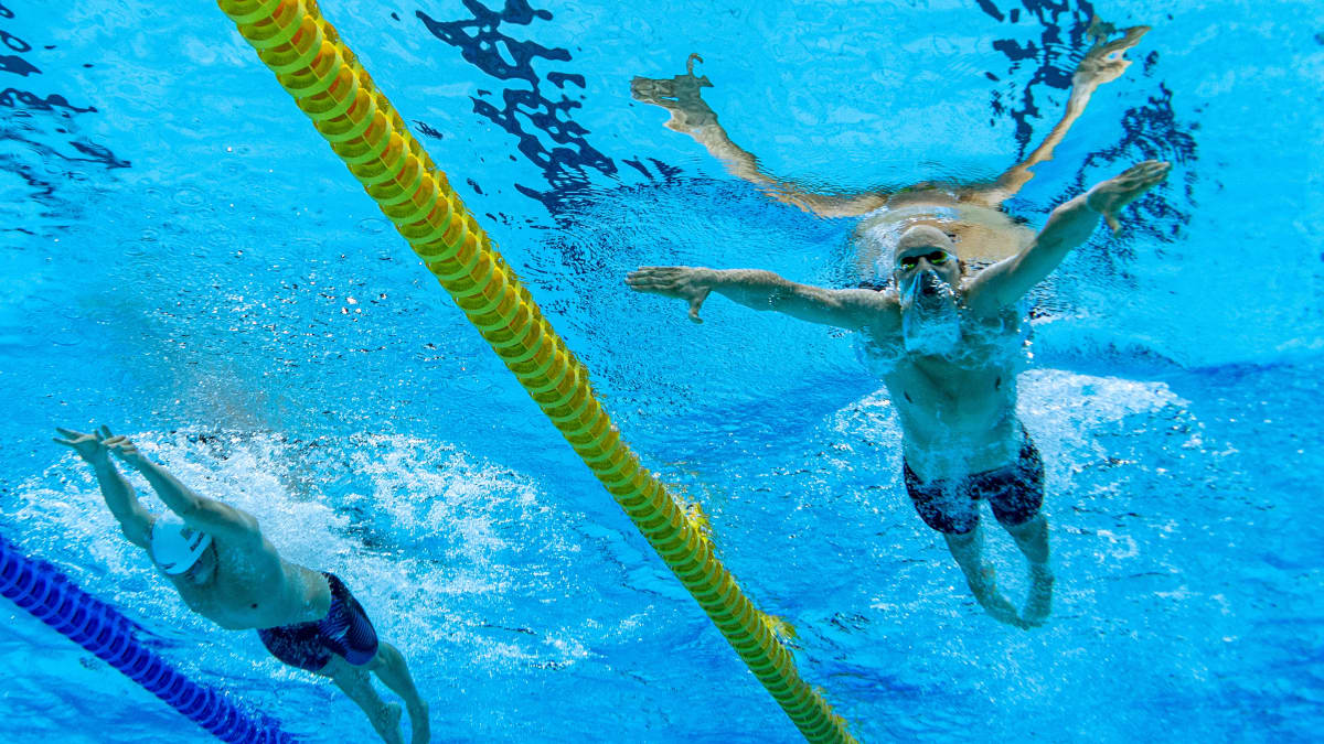 Matti Mattsson kuvattuna alhaalta päin uima-altaassa. Mattssonin pää on veden alla ja kädet kauhovat vettä.