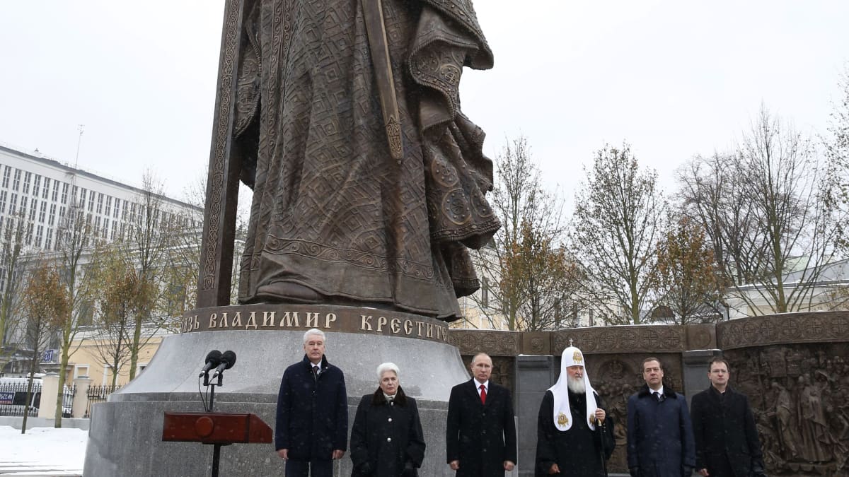 Valtava kivi patsas ja sen edessä mm. Vladimir Putin. 