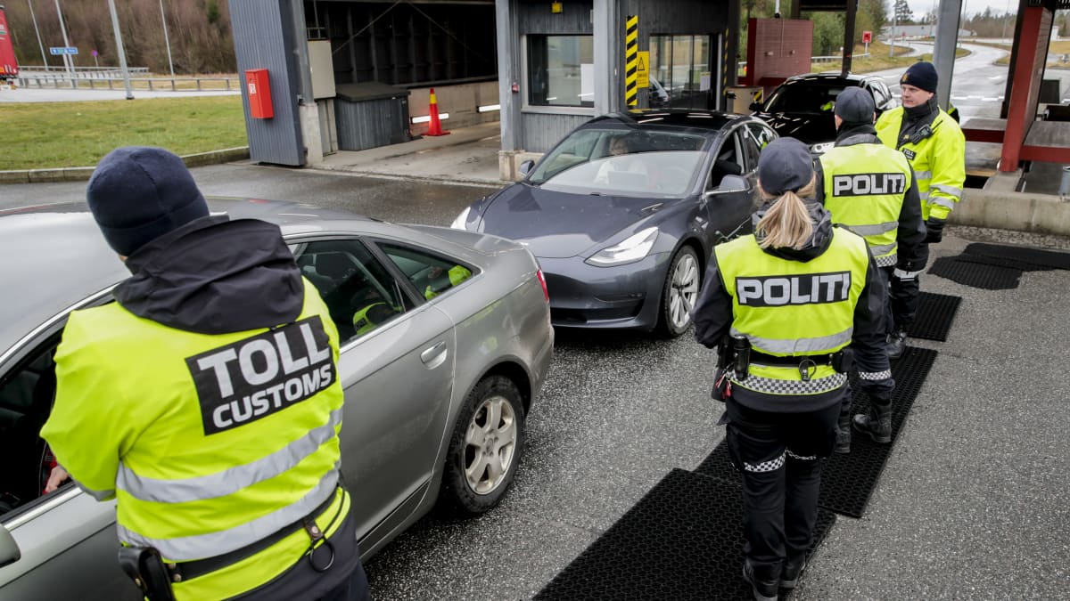 Norjan tullin työntekijöitä rajalle pysäytettyjen autojen lähellä.