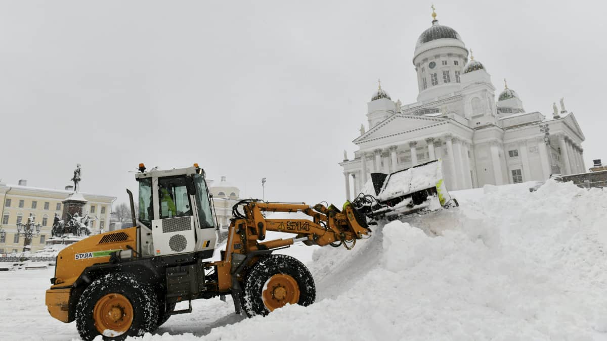 En snöplog lassar snö i en stor snöhög på Senatstorget framför Domkyrkan i Helsingfors under Valtteri-snöstormen.