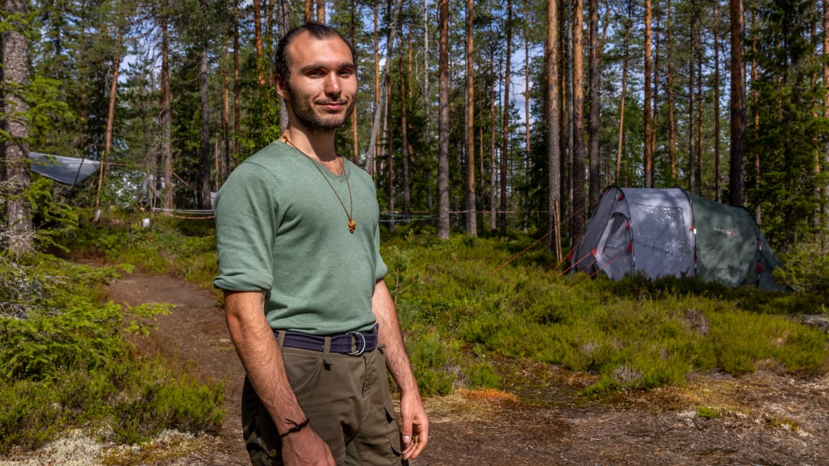 Balihan Ermutlu, Helsinki. Mies metsässä. Taustalla teltta.