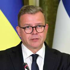 Pääministeri Petteri Orpo, taustalla Ukrainan ja Suomen liput. 