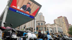 Xi Jinpingin puheen pitämistä näytetään suurella näytöllä katukuvassa.