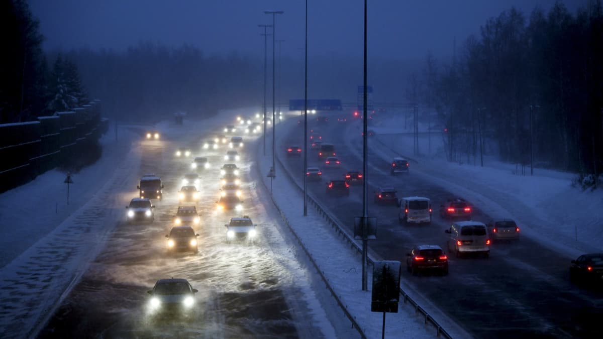 Autojonoja moottoritiellä lumimyrskyssä.