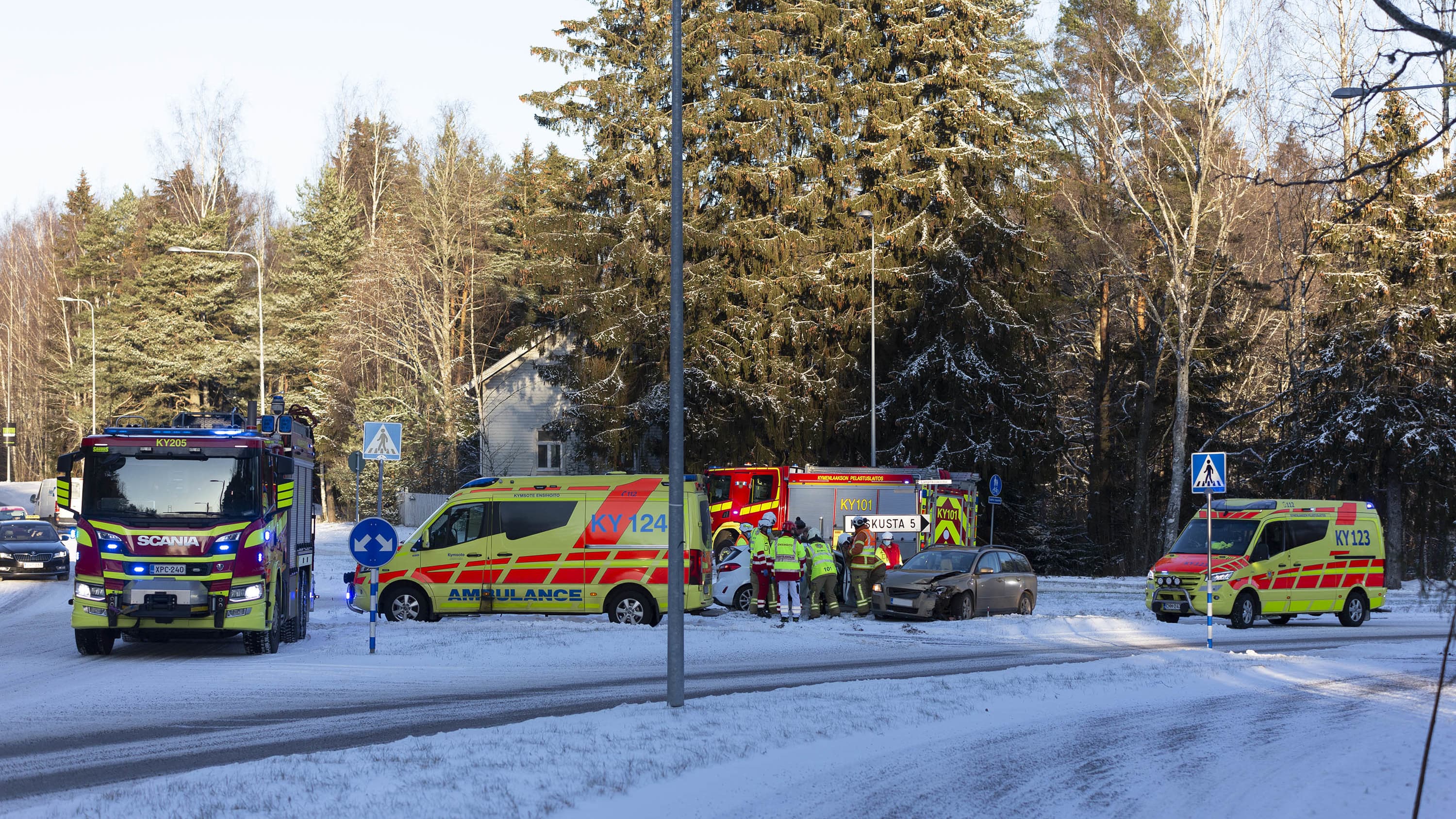 Pelastuslaitoksen ajoneuvoja onnettomuuspaikalla talvisessa risteyksessä Kotkassa. Kaksi henkilöautoa kolaroivat.
