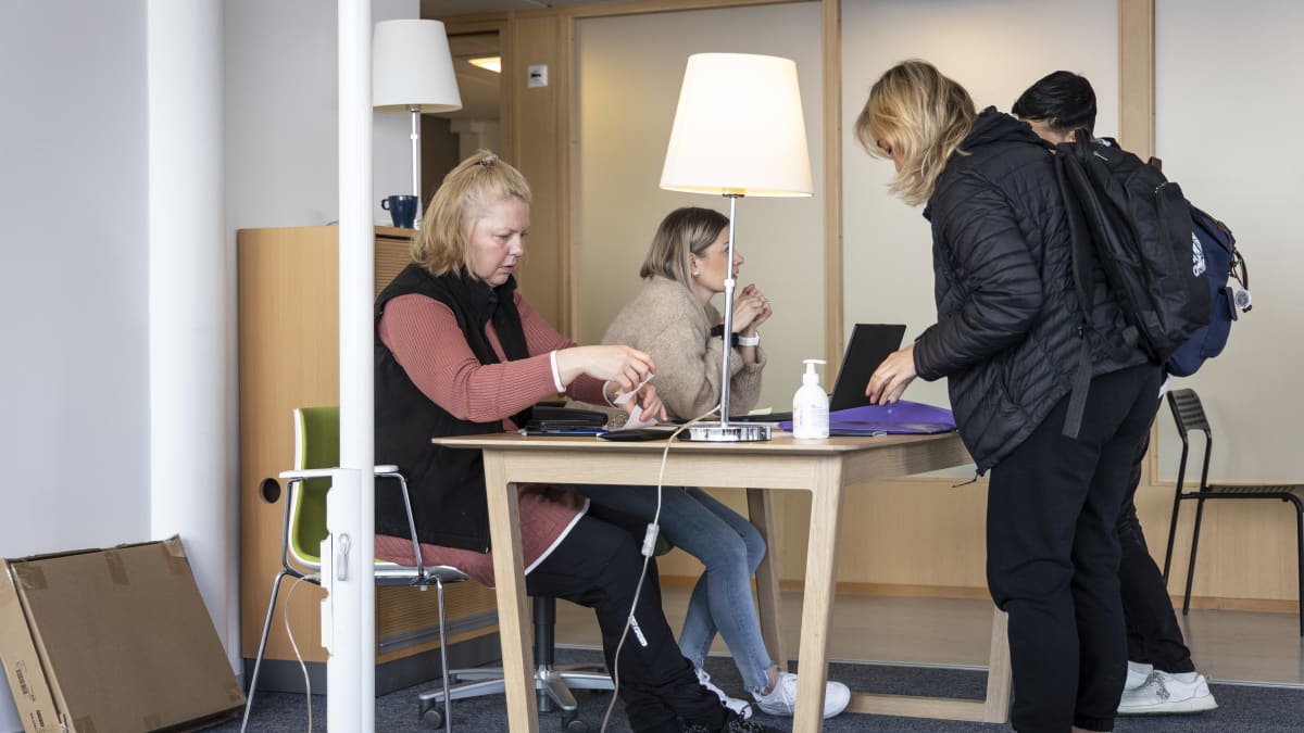 Kuopion vastaanottokeskuksen työntekijät keskustelevat asiakkaiden kanssa