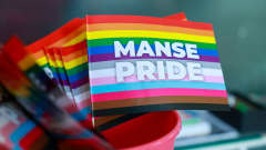 Pieni ja värikäs pride-lippu, jossa valkoisella teksti "Manse Pride".