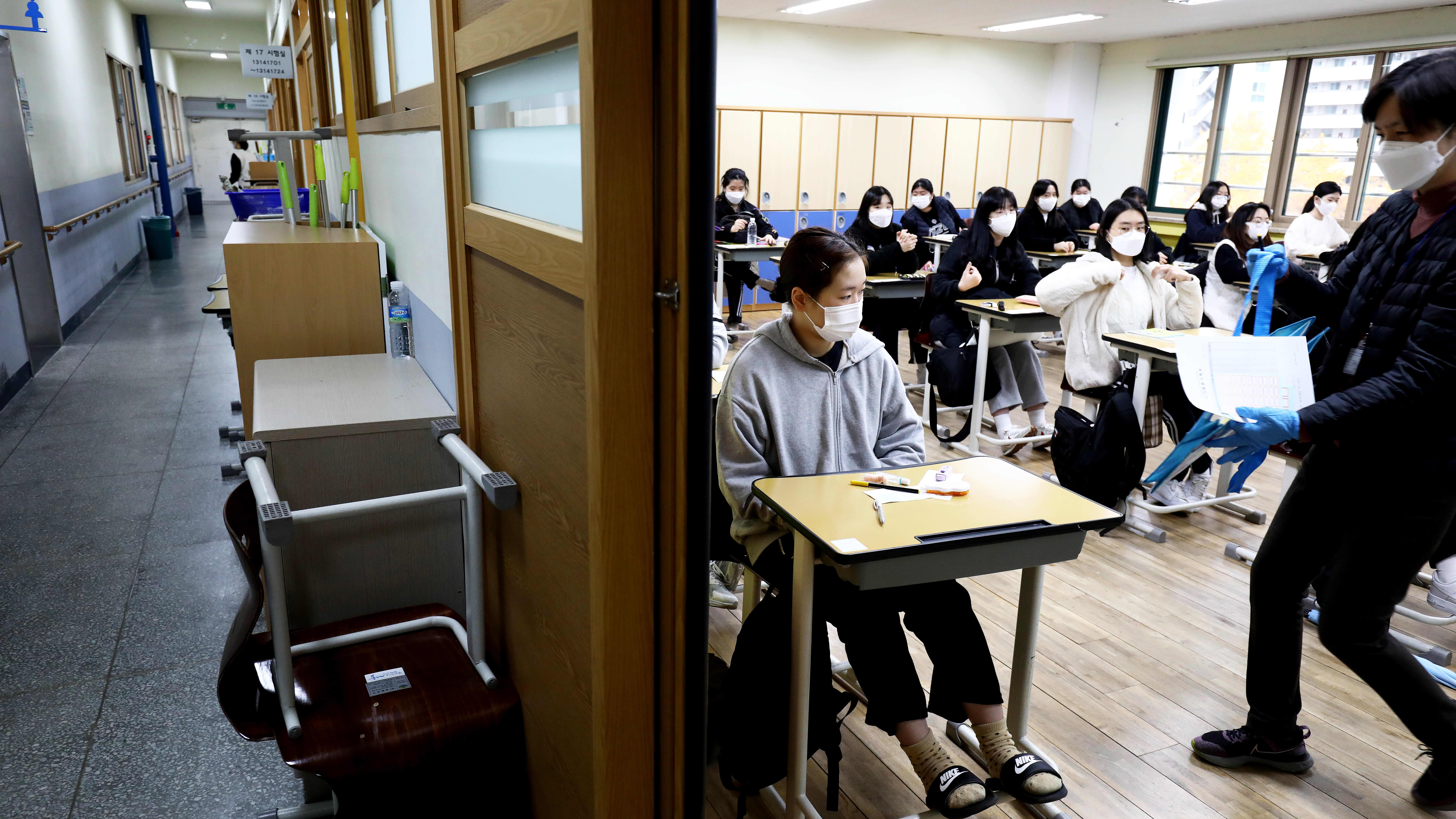 Opiskelijoille jaetaan koepapereita luokkahuoneessa.