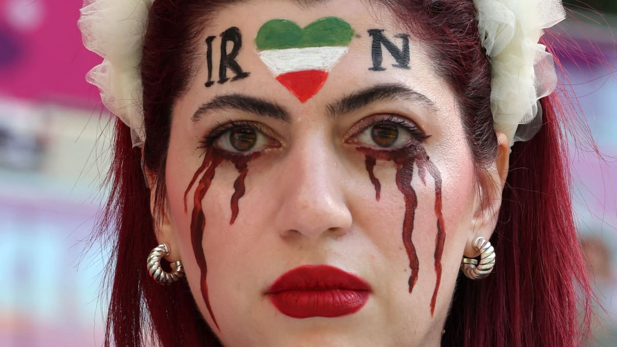 Nainen, jonka kasvoihin on maalattu veriset kyyneleet ja otsaan Iranin lippu.