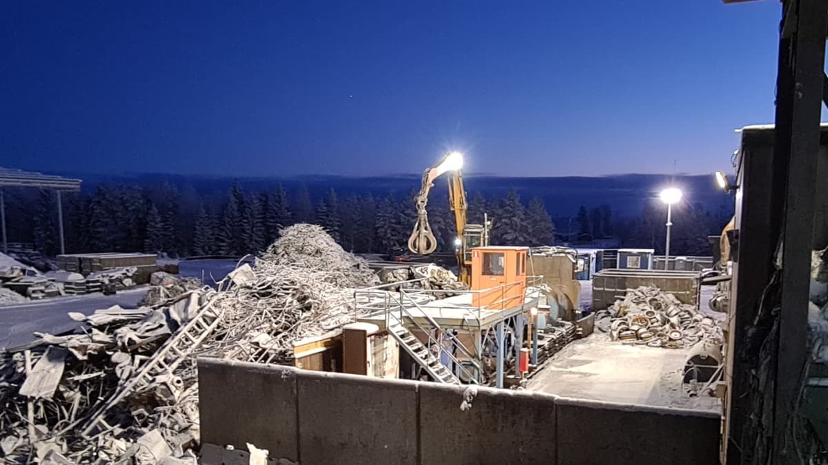 Kuvassa käsiteltäviä romuja, ja materiaalikone joka lajittelee romukouralla tavaroita. 