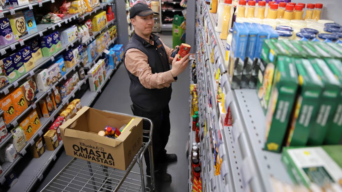 Myyjä Joona Kosunen elintarvikekaupassa keräämässä tuotteita verkkokaupassa tehtyyn tilaukseen.