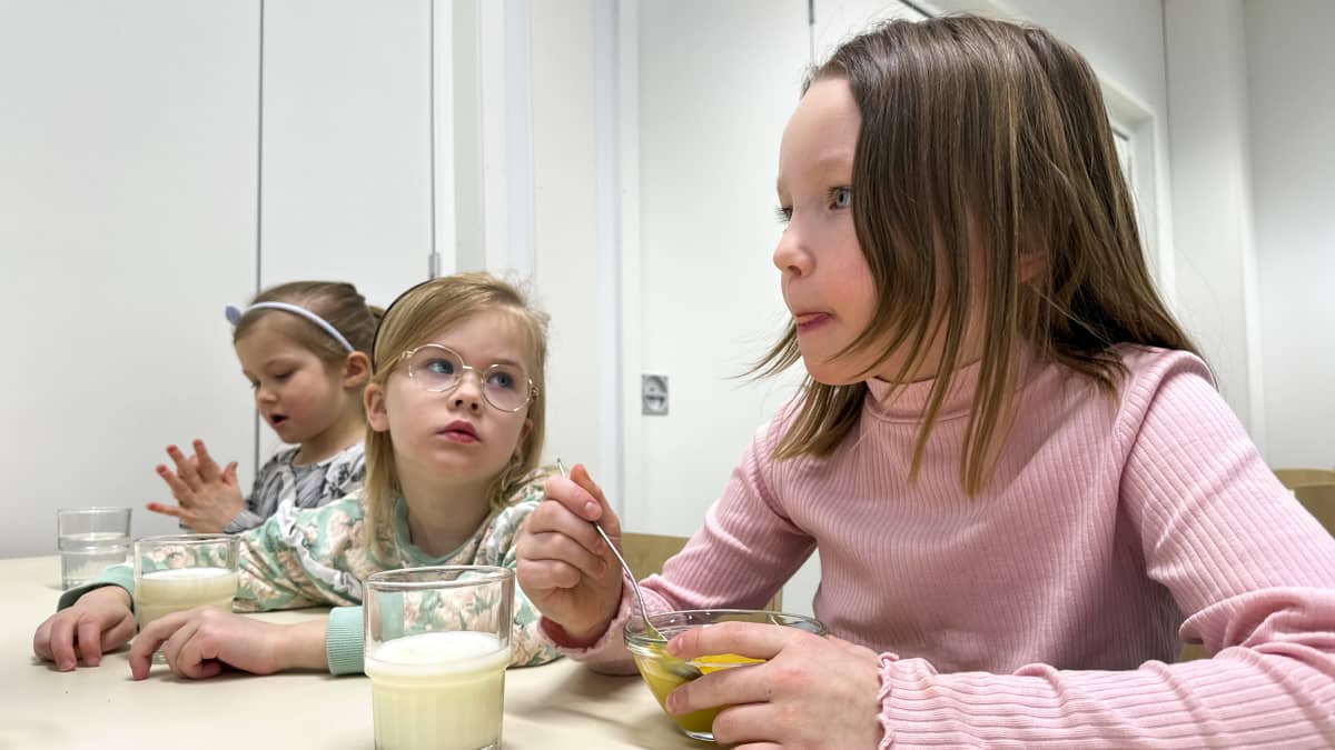 Viola Soinsaari, Helmi Rautakoski ja Aino Rytilä syövät välipalaa Vaskikankaan päiväkodissa Oulussa 14.3.2023