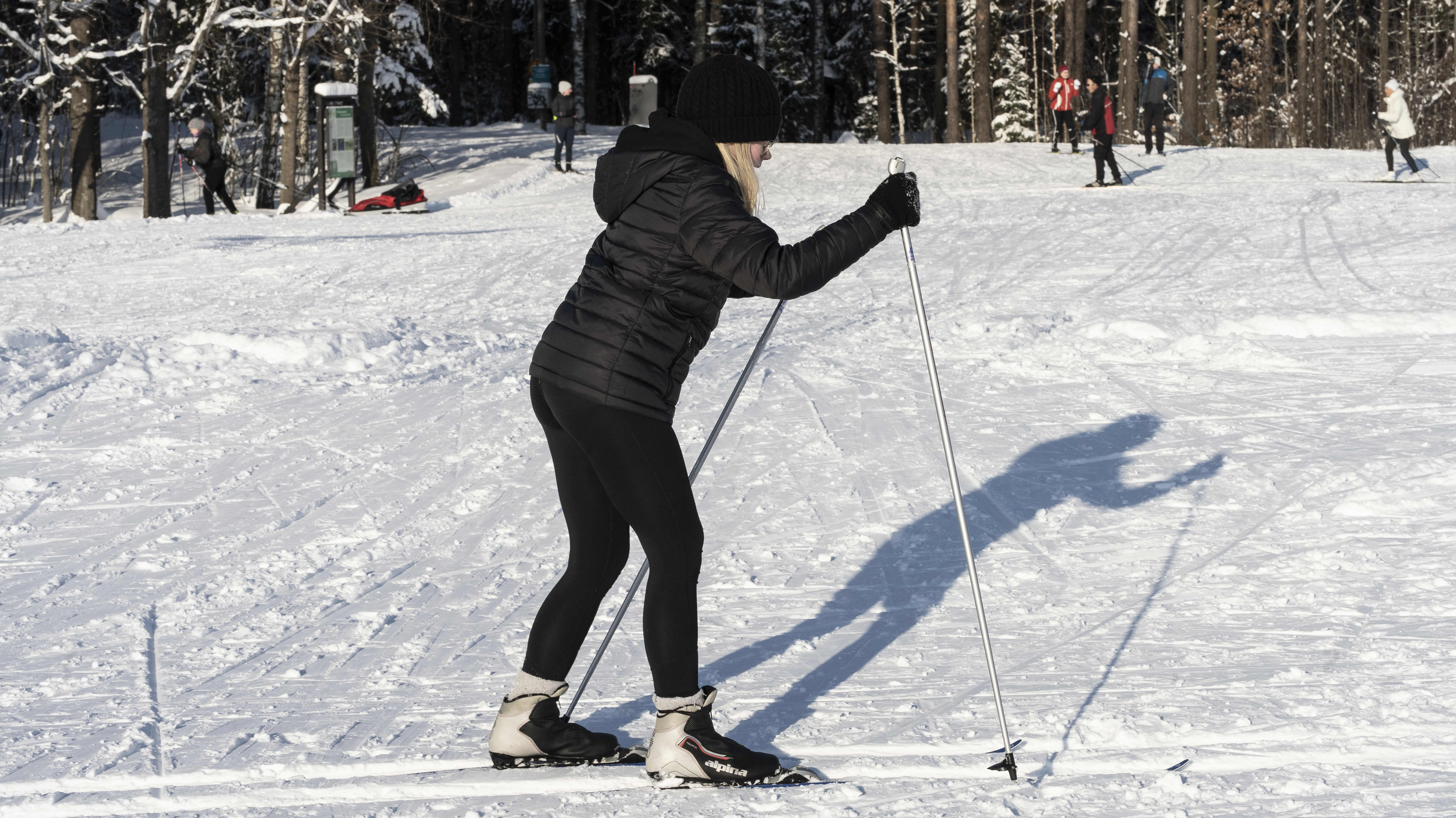 Nuori nainen opettelee hiihtämään Paloheinän hiihtoladulla.