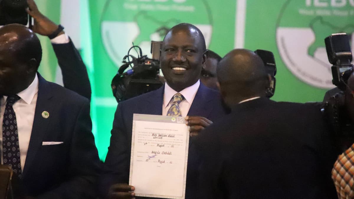 Vastavalittu William Ruto esittelee hänet presidentiksi sertifioivaa sopimuspaperia.