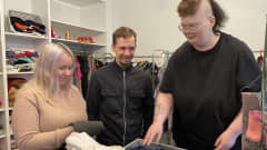 Jenna Häkälä, Eemeli Kumpulainen ja Hanna Nousiainen lajittelevat lahjoituksena saatuja vaatteita Ilmaisessa Puodissa.