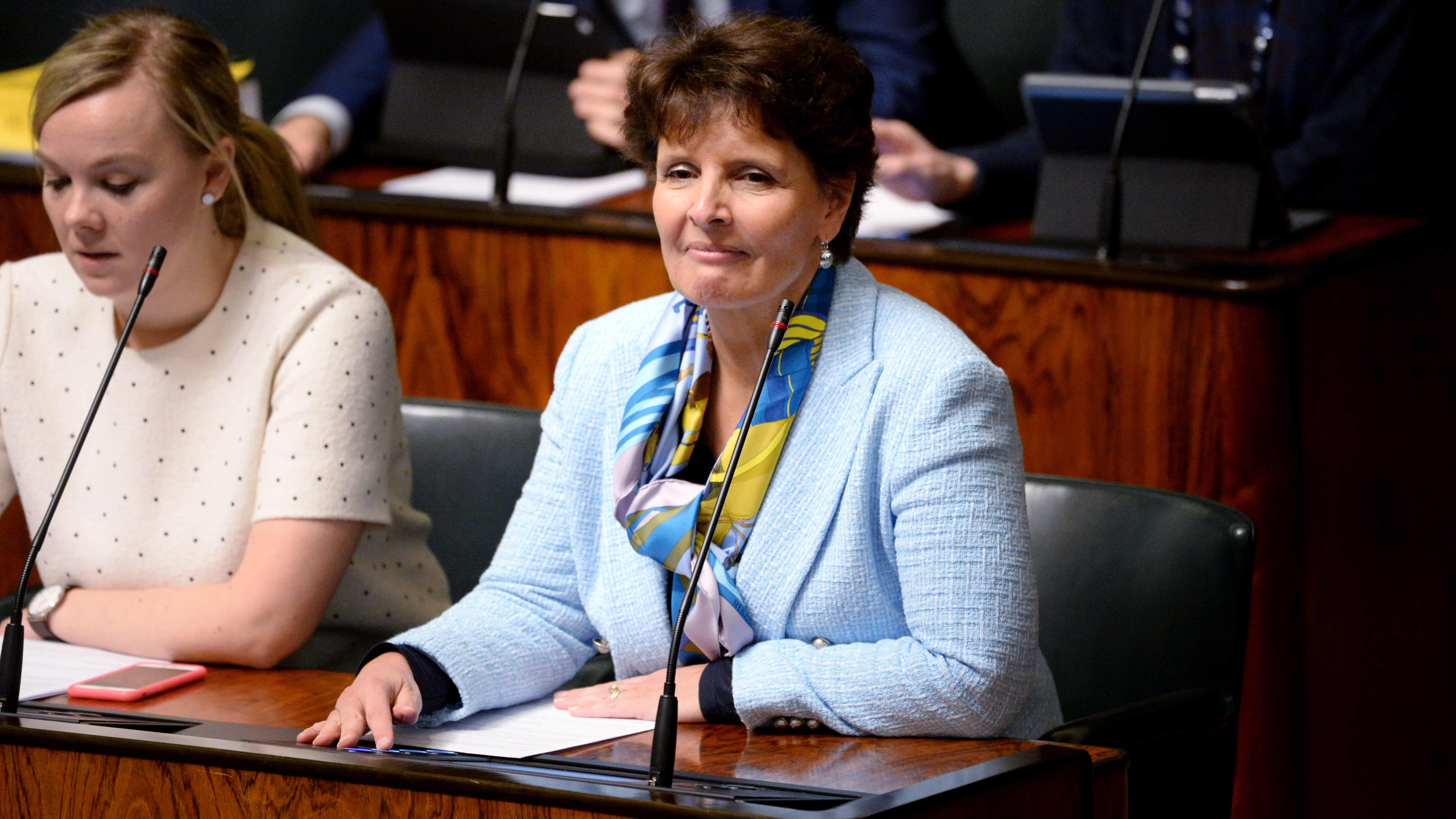 Trafikminister Anne Berner sitter i riksdagsbänken klädd i en ljusblå kavaj.