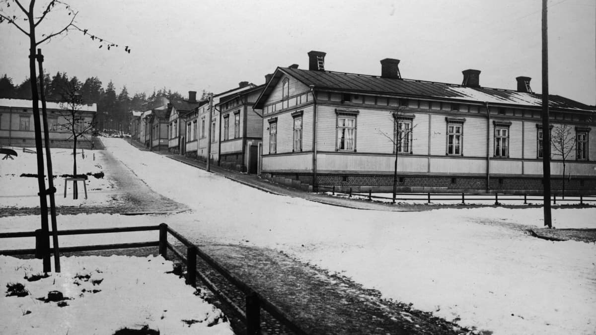 Puuvillatehtaankadun länsipää vuonna 1913. Mustavalkoinen kuva otettu talviaikaan, mutta lunta on vain vähän. Katua reunustavat työväen puukorttelitalot.