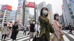 Maskeja käyttäviä ihmisiä Tokion keskustassa.