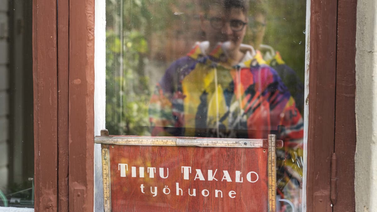 Sarjakuvataiteilija Tiitu Takalon kuva heijastuu hänen työhuoneensa ikkunasta.