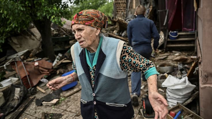 En kvinna utanför sitt förstörda hus i Bachmut, Ukraina den 22 maj 2022.