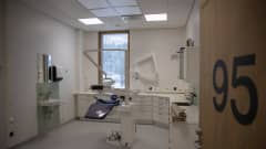 hammaslääkärin vastaanottohuone ovelta nähtynä. Keskellä huonetta on hoitotuoli