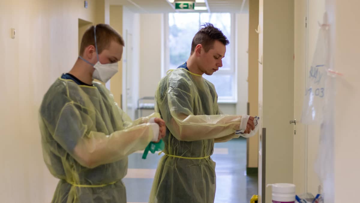 Varusmieslääkintämiehet pukevat suojavarusteitaan Länsi-Tallinnan keskussairaalan koronaosastolla.