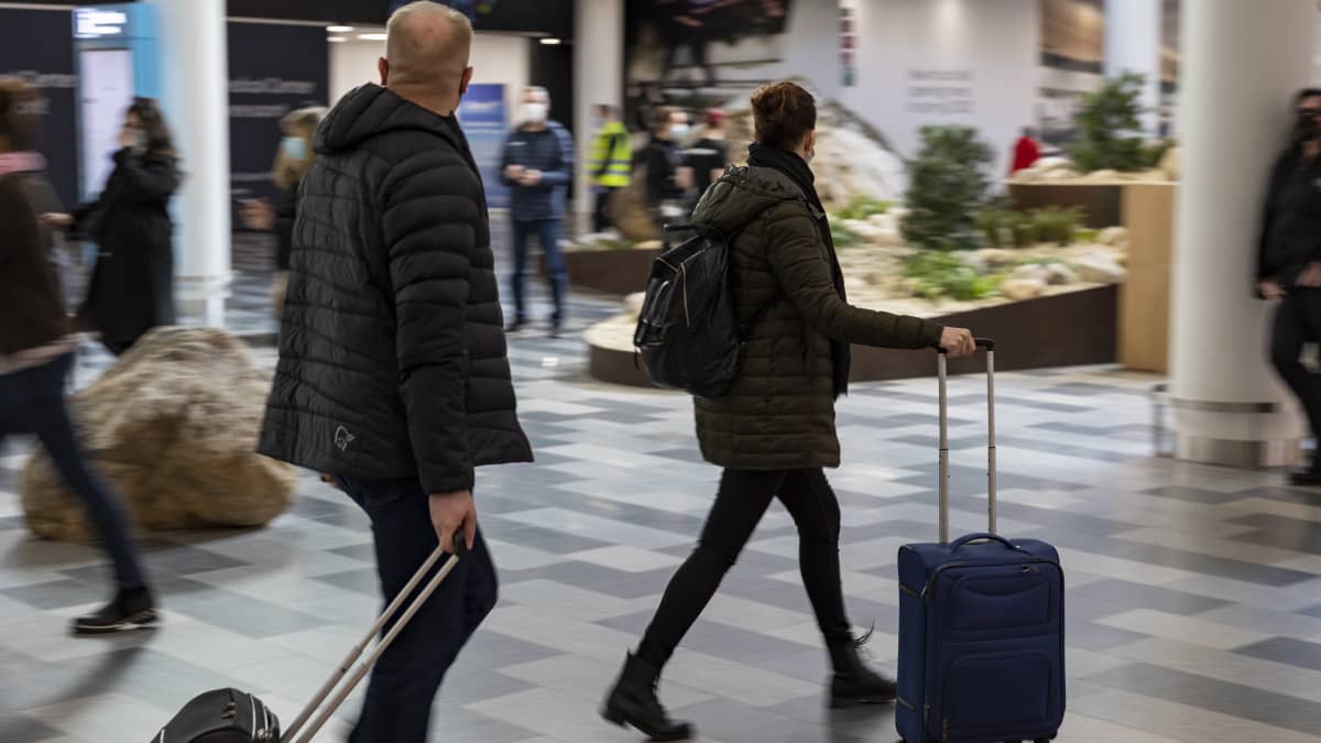 kiireisiä matkustajia Helsinki-Vantaan lentoaseman tuloaulassa.
