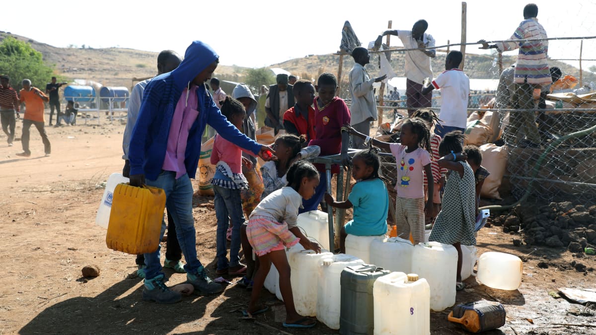 Lapset keräävät vettä kanistereihin Um Rakuban pakolaisleirillä Sudanissa.