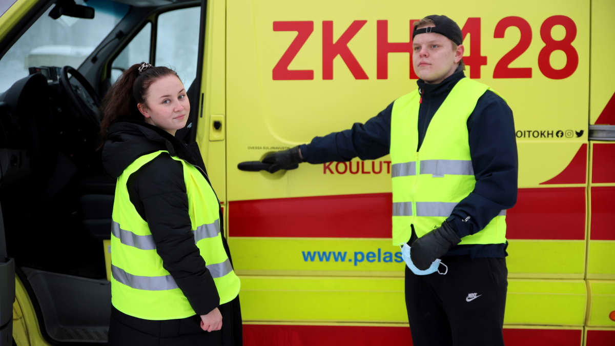 Ensihoidon opiskelijat Mona Ilmanen ja Eetu Hyvärinen ambulanssin edessä.
