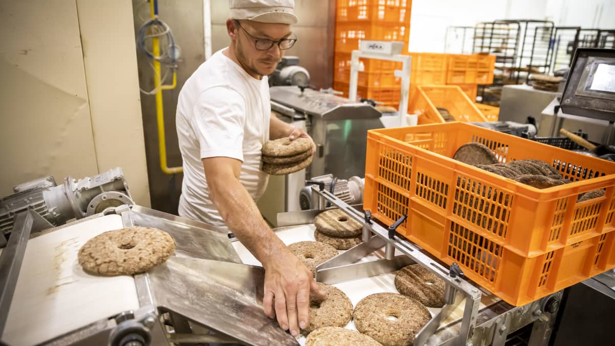 Yrittäjä Markus Vilenius otta ruisleipiä tuotantolinjalta.