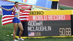 Maailmanennätyksen juossut Sydney McLaughlin Yhdysvaltojen lipun kanssa tulostaulun vieressä.