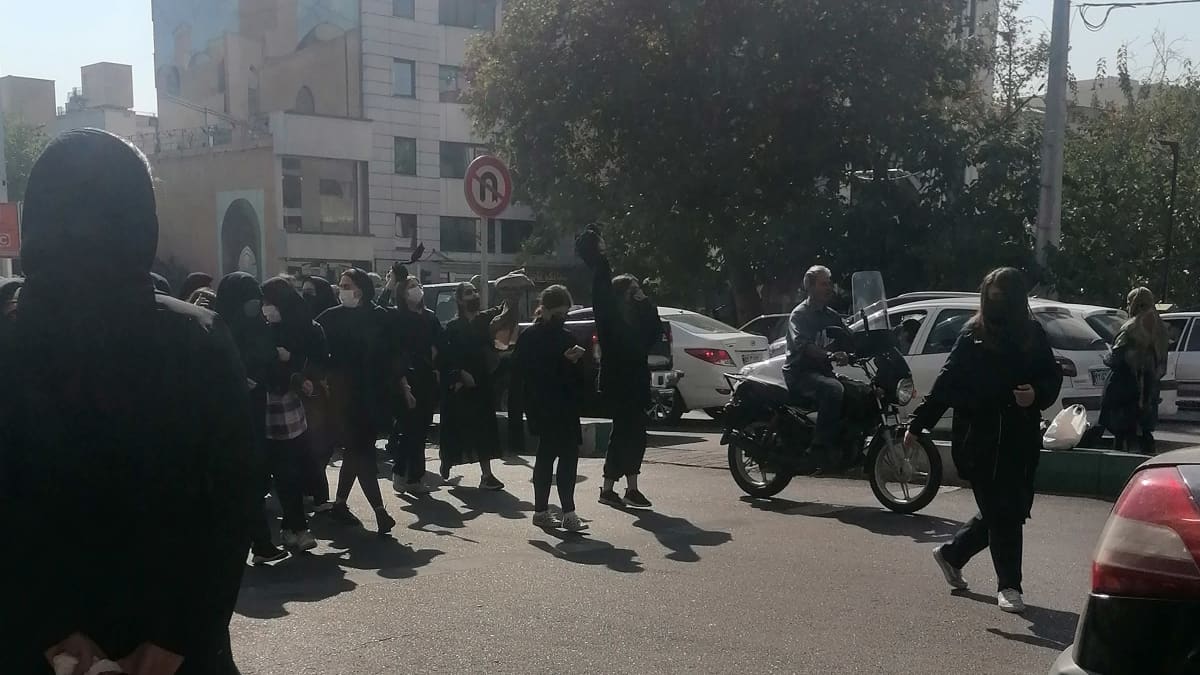 Nuoria naisia mustiin pukeutuneena ilman huivia mielenosoituksessa.