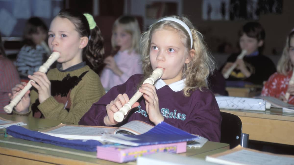 Lapset soittavat nokkahuilua musiikin tunnilla luokkahuoneessa vuonna 1990.
