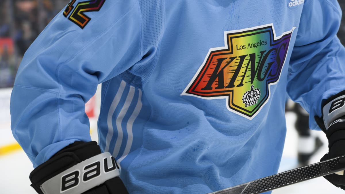 Lähikuva Los Angeles Kings -jääkiekkojoukkueen lämmittelypaidasta, jossa joukkueen logo on sateenkaaren väreissä.