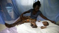 Nainen on suojannut lapsensa verkolla malariahyttysiltä Norsunluurannikolla. 