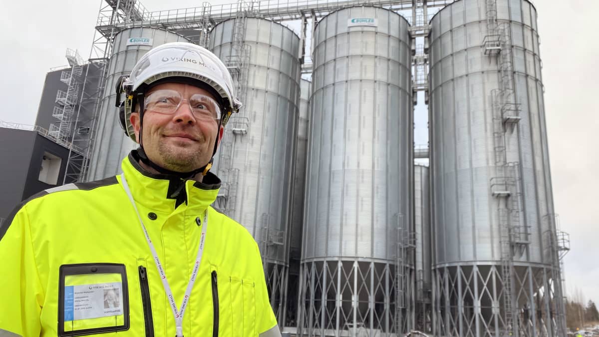 Viking Maltin tuotantojohtaja Kimmo Hietanen taustallaan uuden mallastamon viljasiiloja.