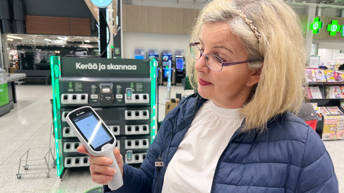 Ylen toimittaja Minna Rosvall katsoo skannaus-laitetta Turussa Tampereentien Prismassa. 
