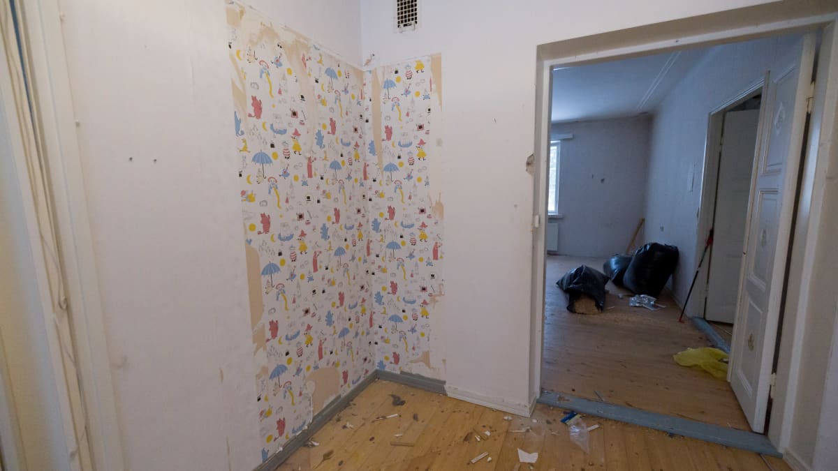 Imatran Ivon asuinalueen kivitalon tyhjä huone. Seinästä revitty kerroksia tapettia. Alta paljastuu Muumi-aiheinen lasten tapetti.