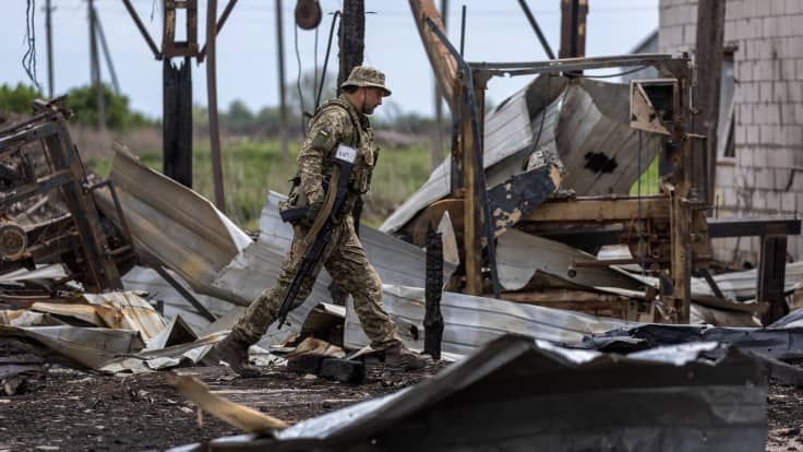 Ukrainalainen sotilas kävelee pommituksessa tuhoutuneen rakennuksen raunioissa.