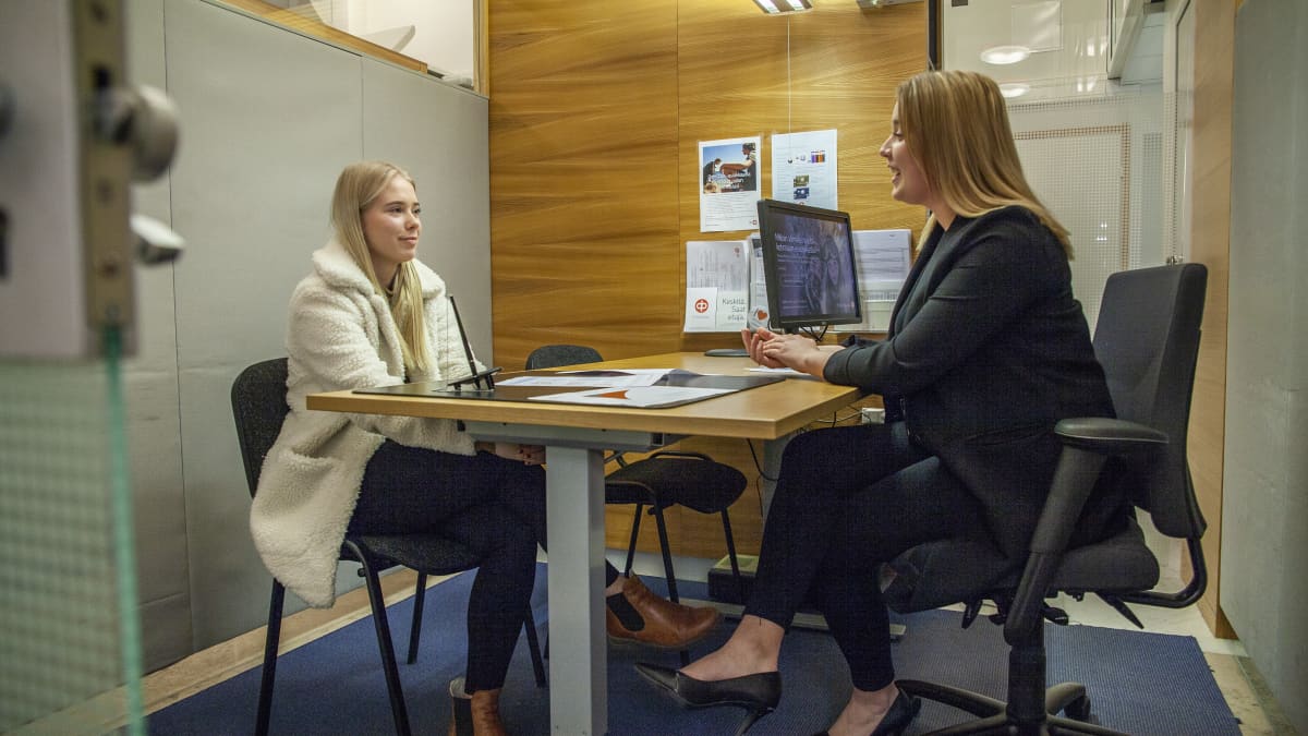 Pohjois-Savon Osuuspankin asiakasneuvoja Julia Jerkku keskustelee raha-asioista Kuopiolaisen nuoren Olivia Honkosen kanssa.